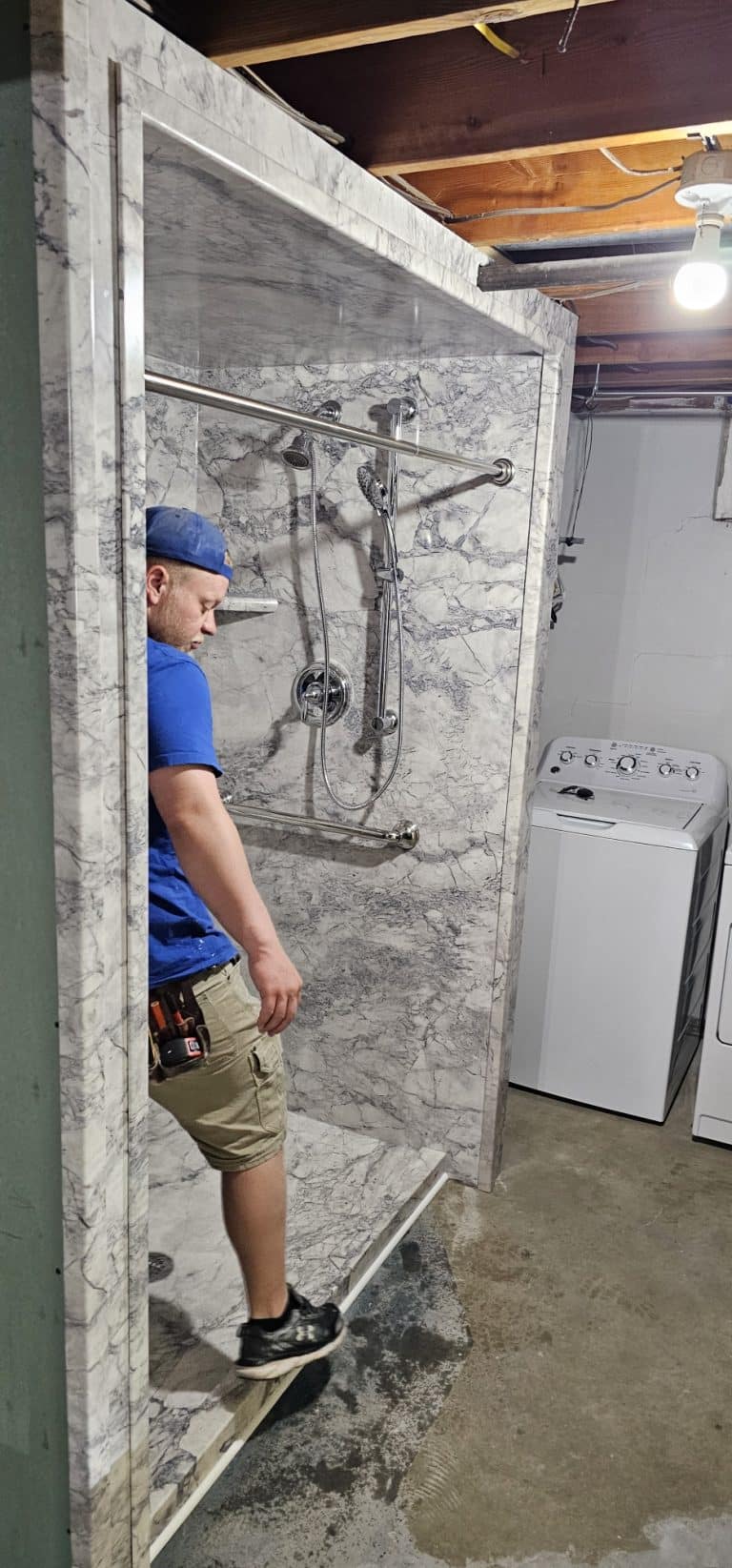 A professional installer performs a precise shower removal in a bathroom.